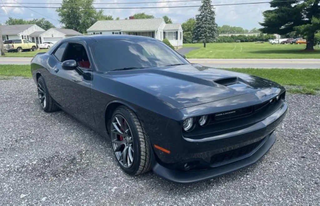 Czarny Dodge Challenger SRT 392 – ujęcie 3/4 z przodu z lewej, maska z wlotem powietrza, sportowe felgi, przyciemnione szyby.