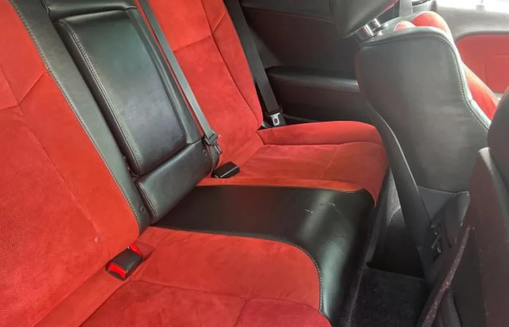 Tylna kanapa Dodge Challenger – tapicerka alcantara czerwień z czarną skórą, składane oparcia.