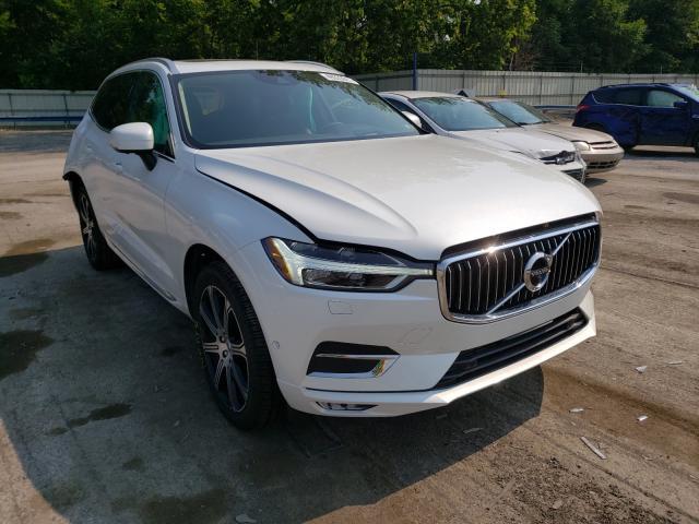 Białe Volvo XC60 z uchyloną maską, widok z przodu-lewego boku na parkingu
