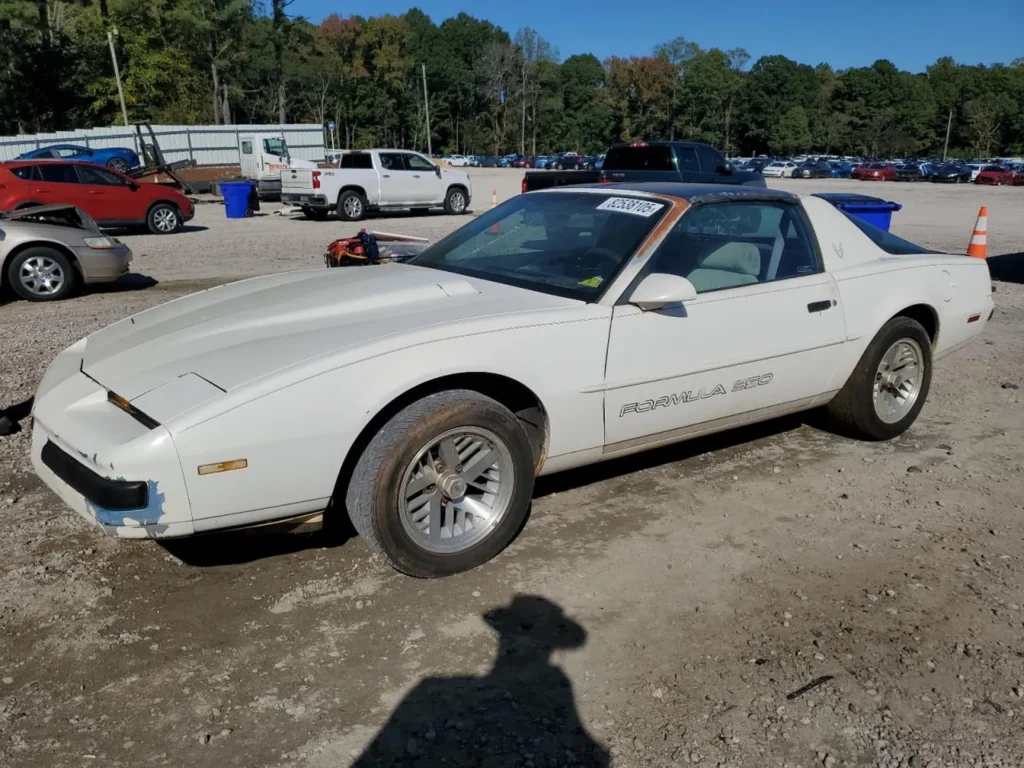 Biały Pontiac Firebird Formula 350 (III gen) – lewy przód, coupe T-top, widoczne zarysowania i odpryski na zderzaku.
