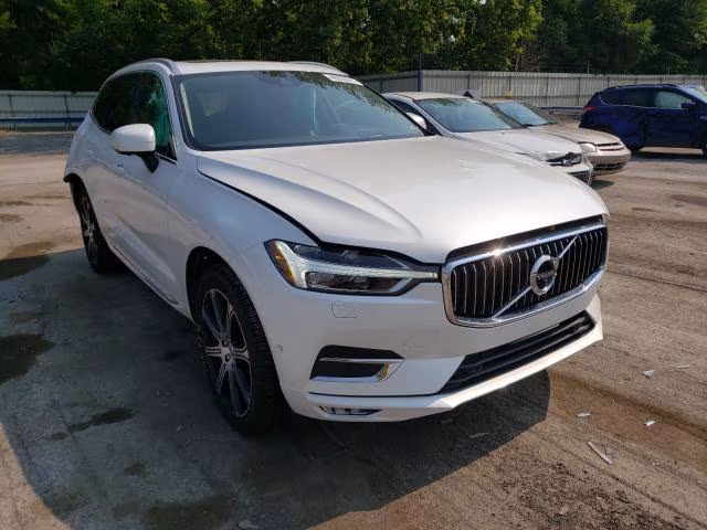 Białe Volvo XC60 z uchyloną maską, widok z przodu-lewego boku na parkingu