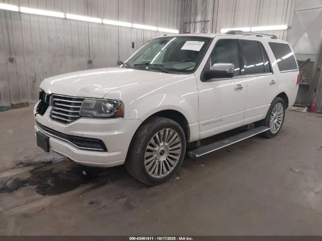 Biały Lincoln Navigator z przodu z lewej, w hali warsztatowej, brak znaczka na grillu.