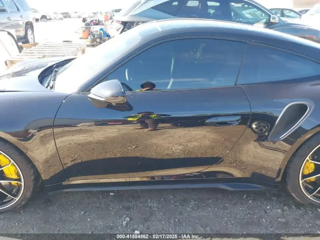 Lewy bok Porsche 911 Turbo S – zbliżenie na drzwi, lusterko i wlot powietrza w tylnym błotniku, żółte zaciski hamulcowe.