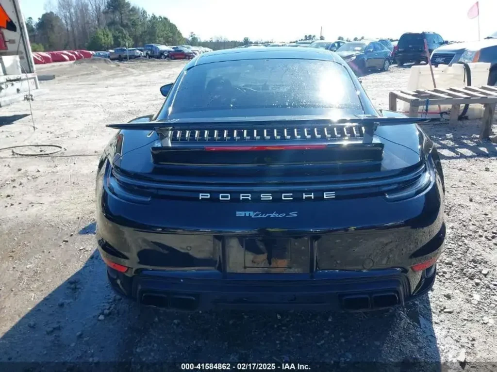 Tył Porsche 911 Turbo S – centralny napis PORSCHE, belka świetlna i spoiler, podwójne prostokątne końcówki wydechu.