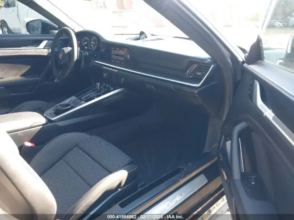 Wnętrze Porsche 911 Turbo S – kokpit z czarną tapicerką, sportowe fotele, kierownica wielofunkcyjna i konsola środkowa PDK.