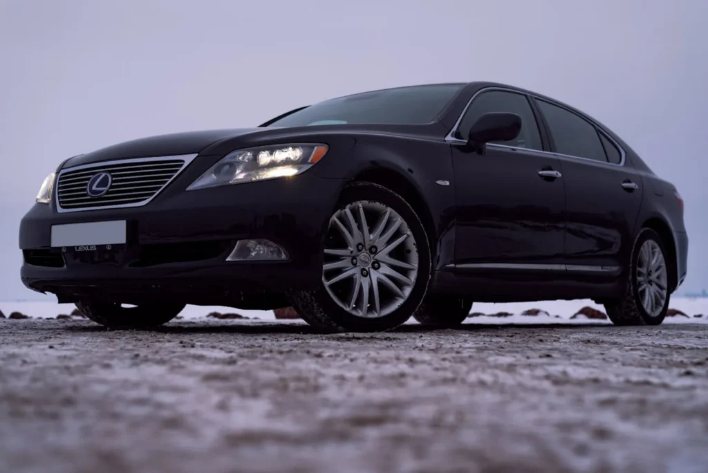 Czarny sedan Lexus LS na ośnieżonym podłożu – luksusowy samochód klasy premium sfotografowany zimą.