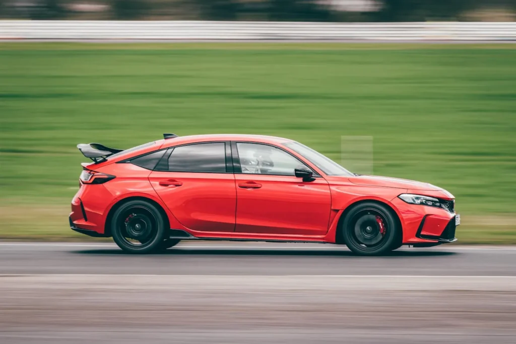 Honda Civic Type R w ruchu na torze wyścigowym, ujęcie z boku