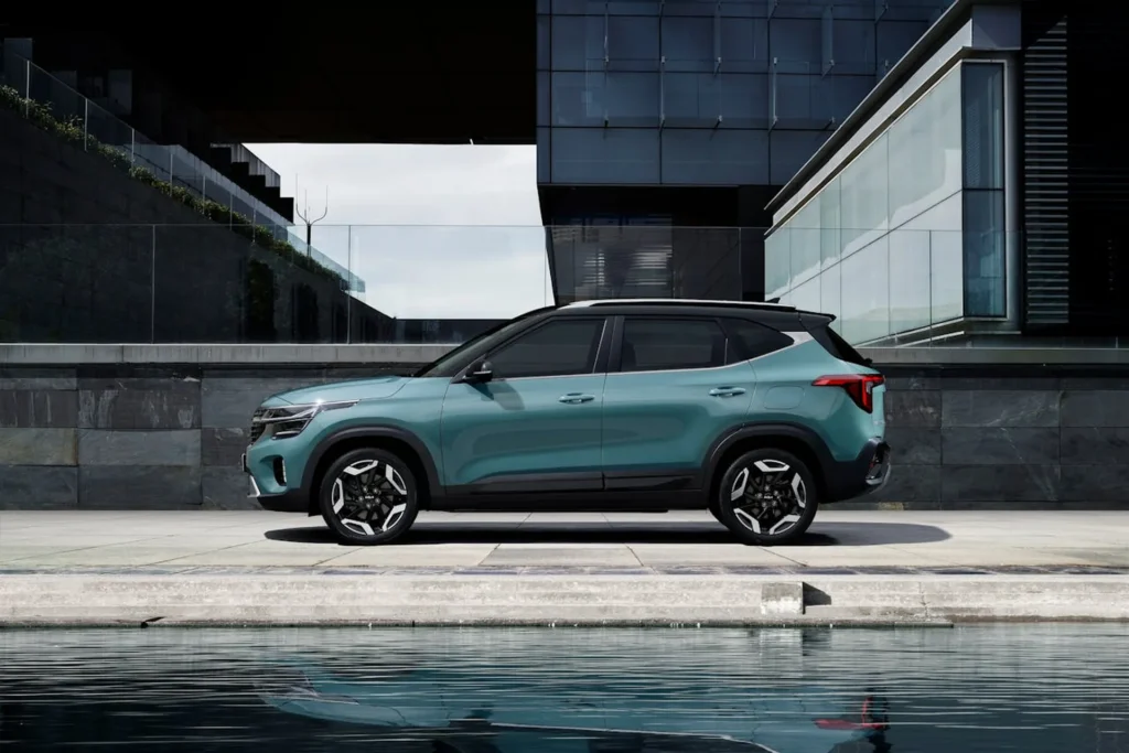 Nowoczesny SUV KIA w niebiesko-zielonym kolorze zaparkowany przy szklanym budynku