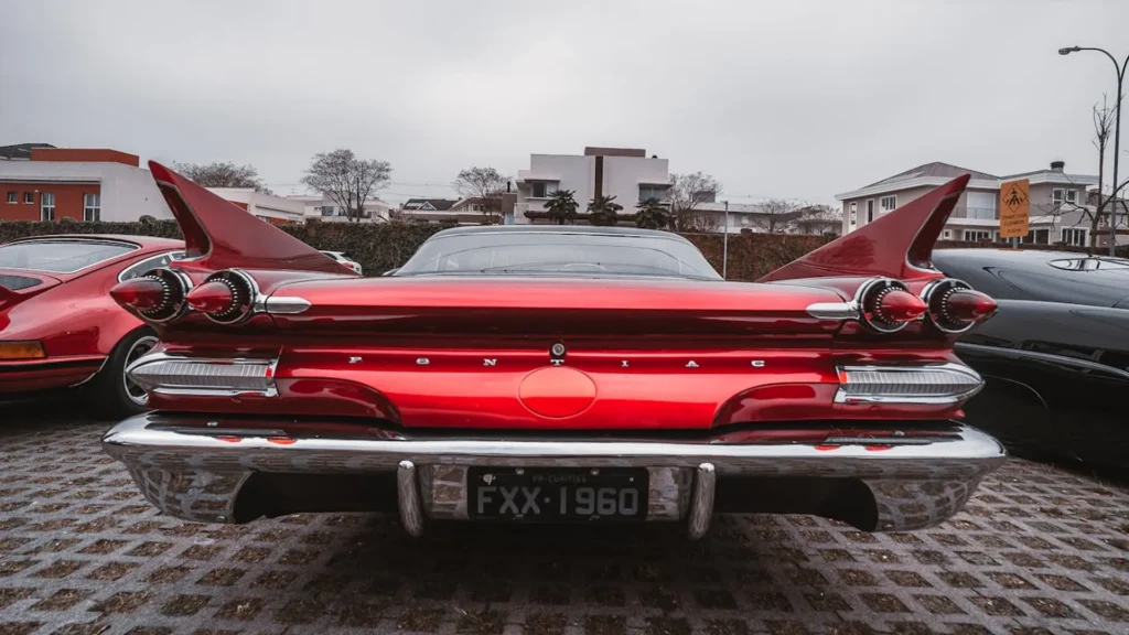 Tył czerwonego Pontiaca Bonneville z USA z 1960 roku z dużymi płetwami i czterema okrągłymi światłami