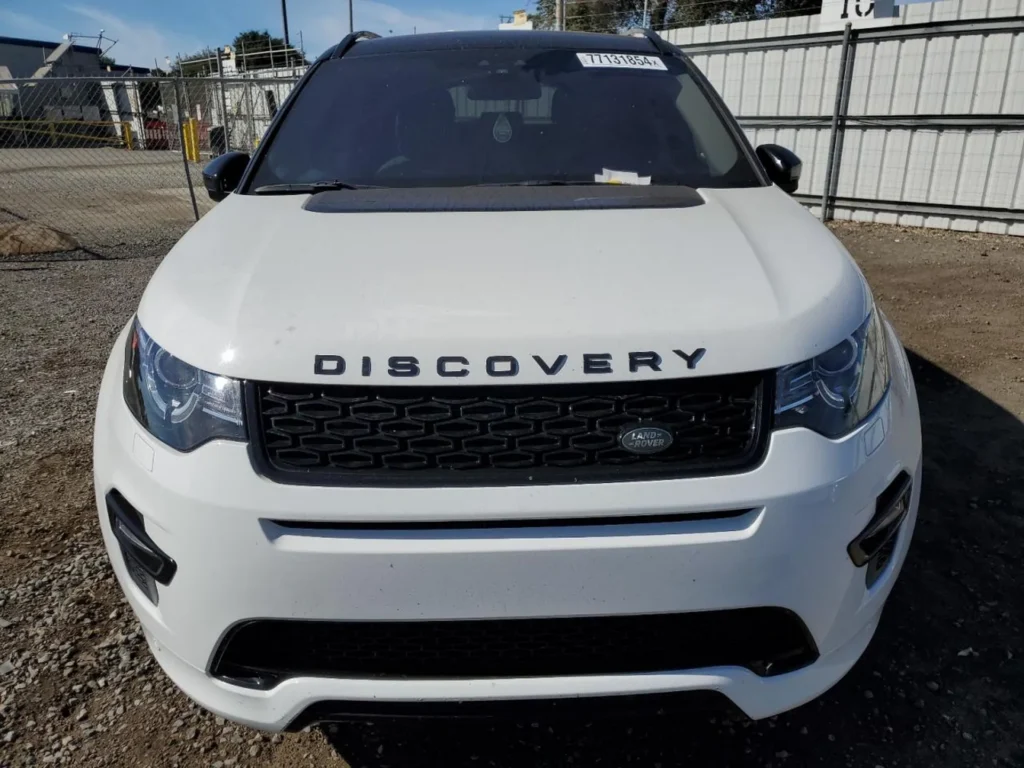 Przód samochodu z napisem DISCOVERY na masce, czarny grill i reflektory LED.