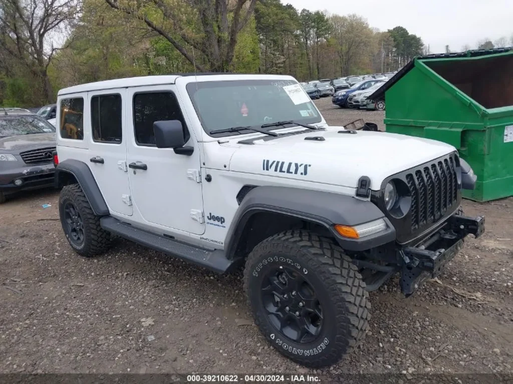 Biały Jeep Wrangler Unlimited Willys 4xe z podniesionym zawieszeniem i agresywnymi oponami; brak przedniego zderzaka.
