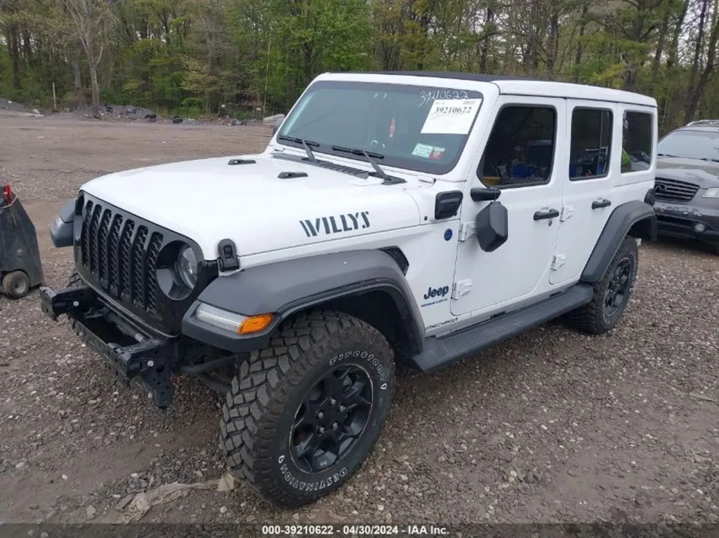 Prawy przód Jeepa Wrangler Willys 4xe; widoczna kratka grilla, poszerzone nadkola, brak zderzaka.
