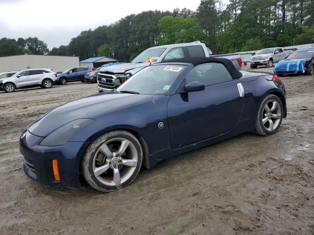 Nissan 350Z Cabrio 2007, granatowy, lewy przód, dach miękki, opony w błocie, plac aukcyjny