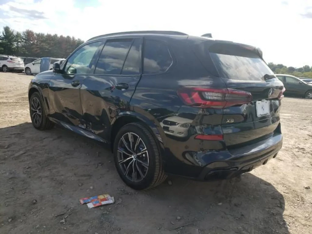 Tył i lewy bok BMW X5, zagniecenia na prawym boku, emblemat X5.