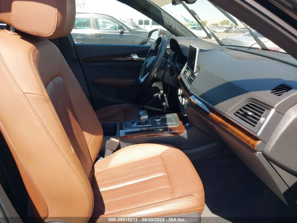 Wnętrze Audi Q5, brązowe fotele, kokpit z drewnianymi wstawkami.