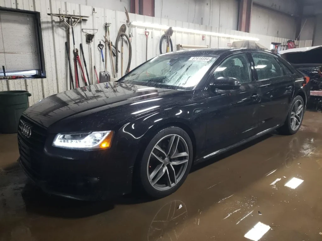 Czarny sedan Audi A8L w hali warsztatowej, widok z przodu pod skosem
