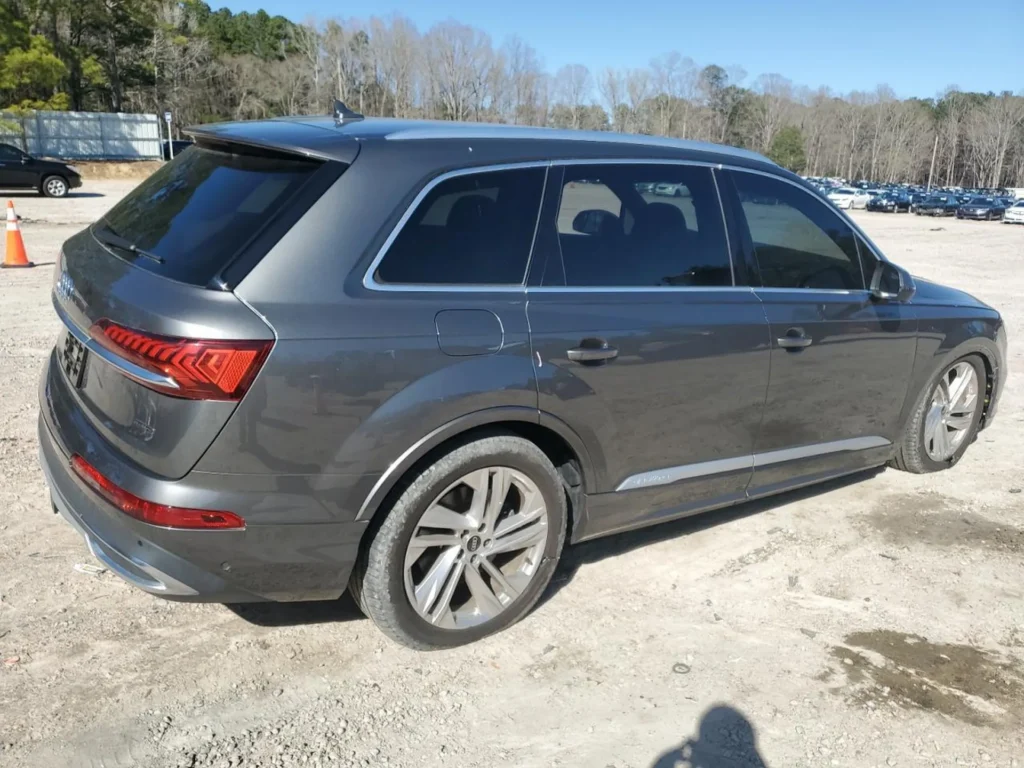 Tył i prawa strona szarego Audi Q7 zaparkowanego na otwartym placu