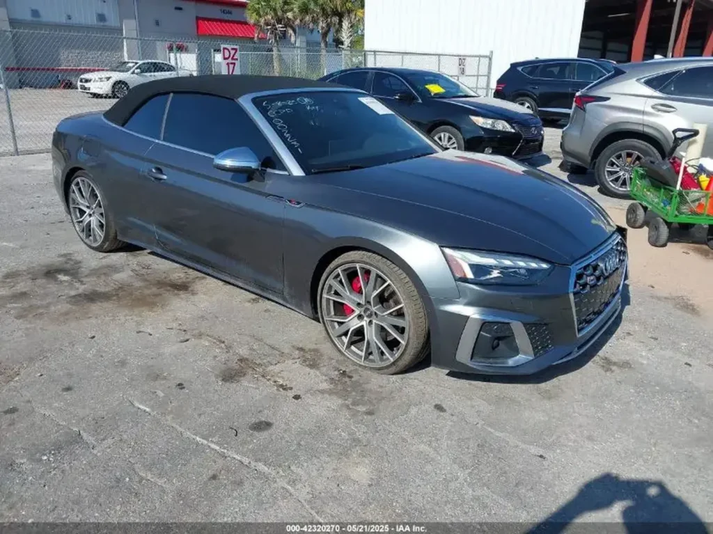 Szary kabriolet Audi S5 z czarnym miękkim dachem widziany z lewej strony na parkingu