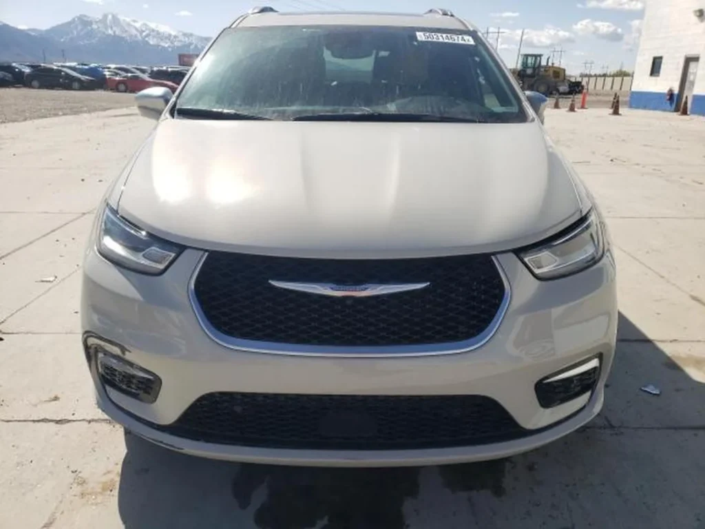 Jasny Chrysler Pacifica po liftingu, ujęcie z przodu pokazujące grill i reflektory.