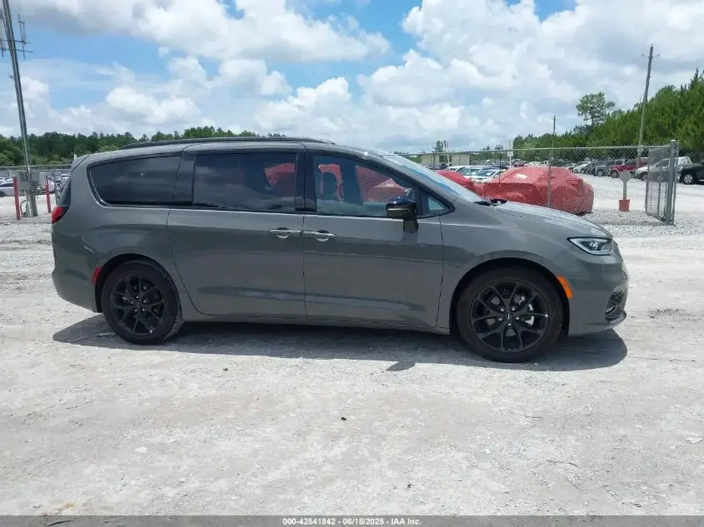 Szary Chrysler Pacifica po liftingu, widok z boku na placu z innymi samochodami.