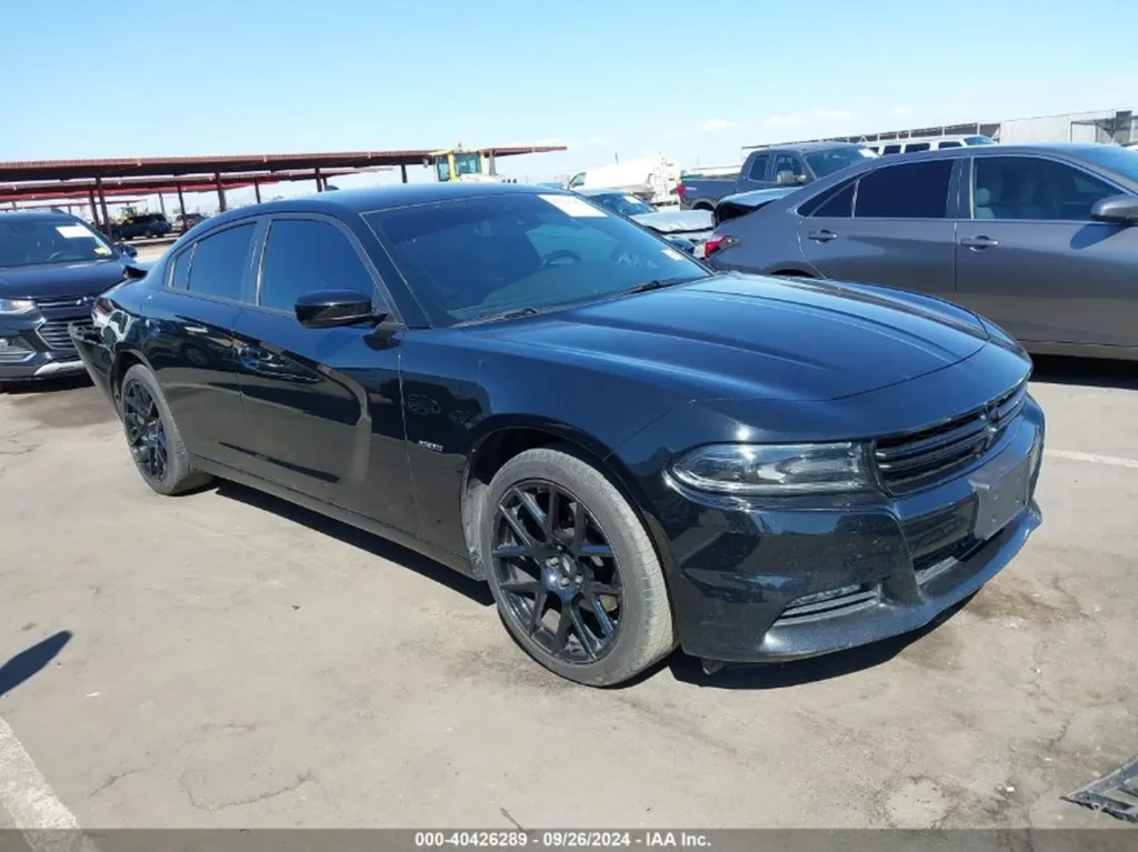 zarny Dodge Charger z przyciemnianymi szybami, widok z lewego przodu na słonecznym placu.