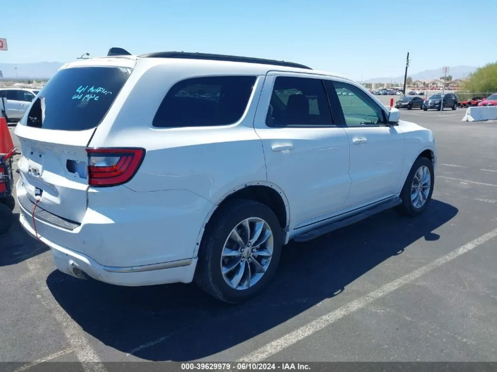Biały Dodge Durango z tyłu i z lewej strony, częściowo zdemontowany tylny zderzak i klapa bagażnika.