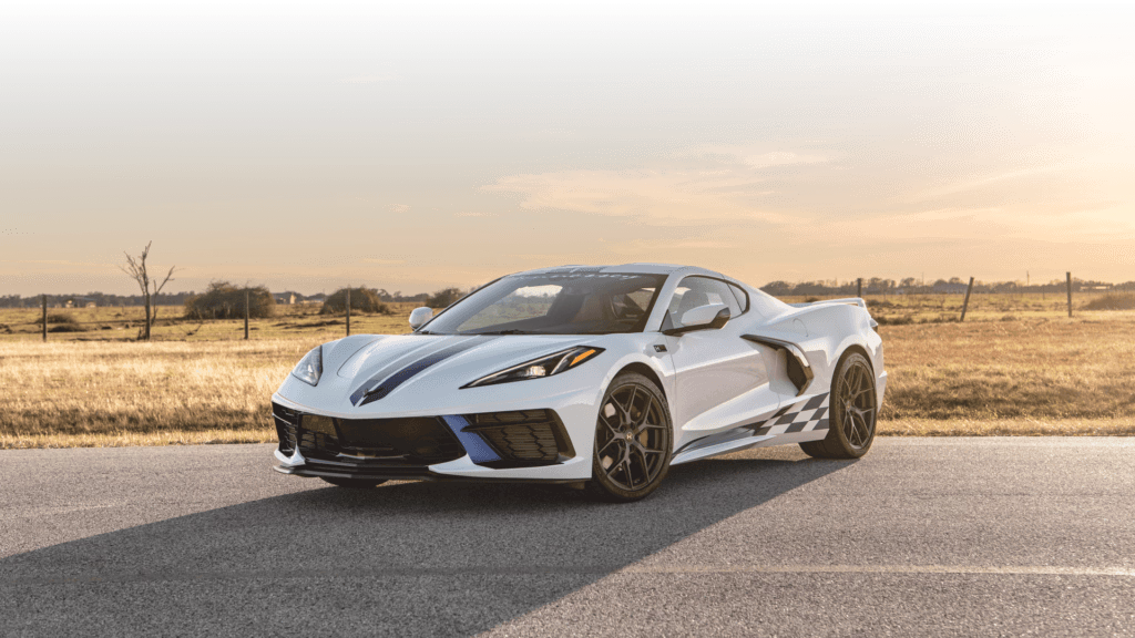 Biały Chevrolet Corvette C8 stoi na wiejskiej drodze o zachodzie słońca