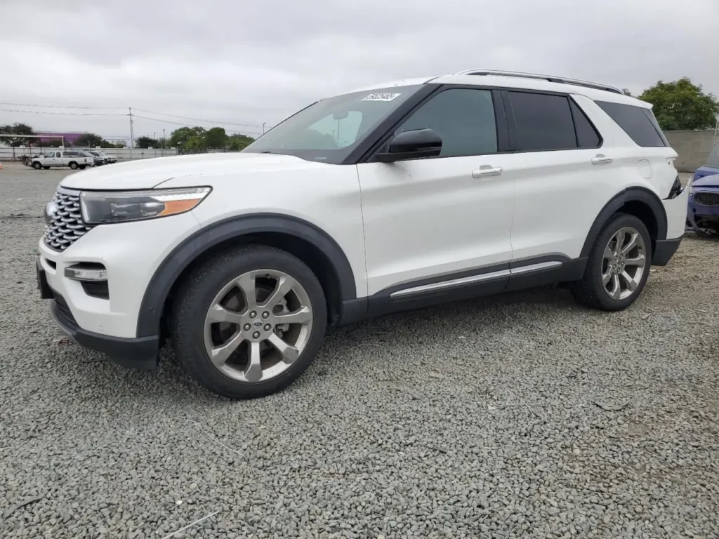 Biały Ford Explorer SUV zaparkowany na żwirowym placu, widok z przodu i boku