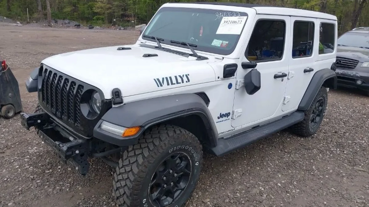 Prawy przód Jeepa Wrangler Willys 4xe; widoczna kratka grilla, poszerzone nadkola, brak zderzaka.