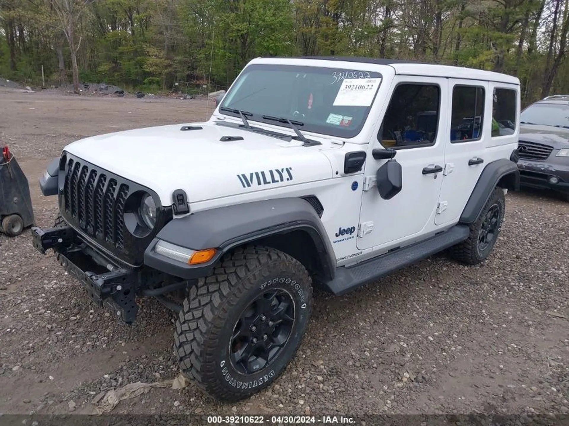 Prawy przód Jeepa Wrangler Willys 4xe; widoczna kratka grilla, poszerzone nadkola, brak zderzaka.